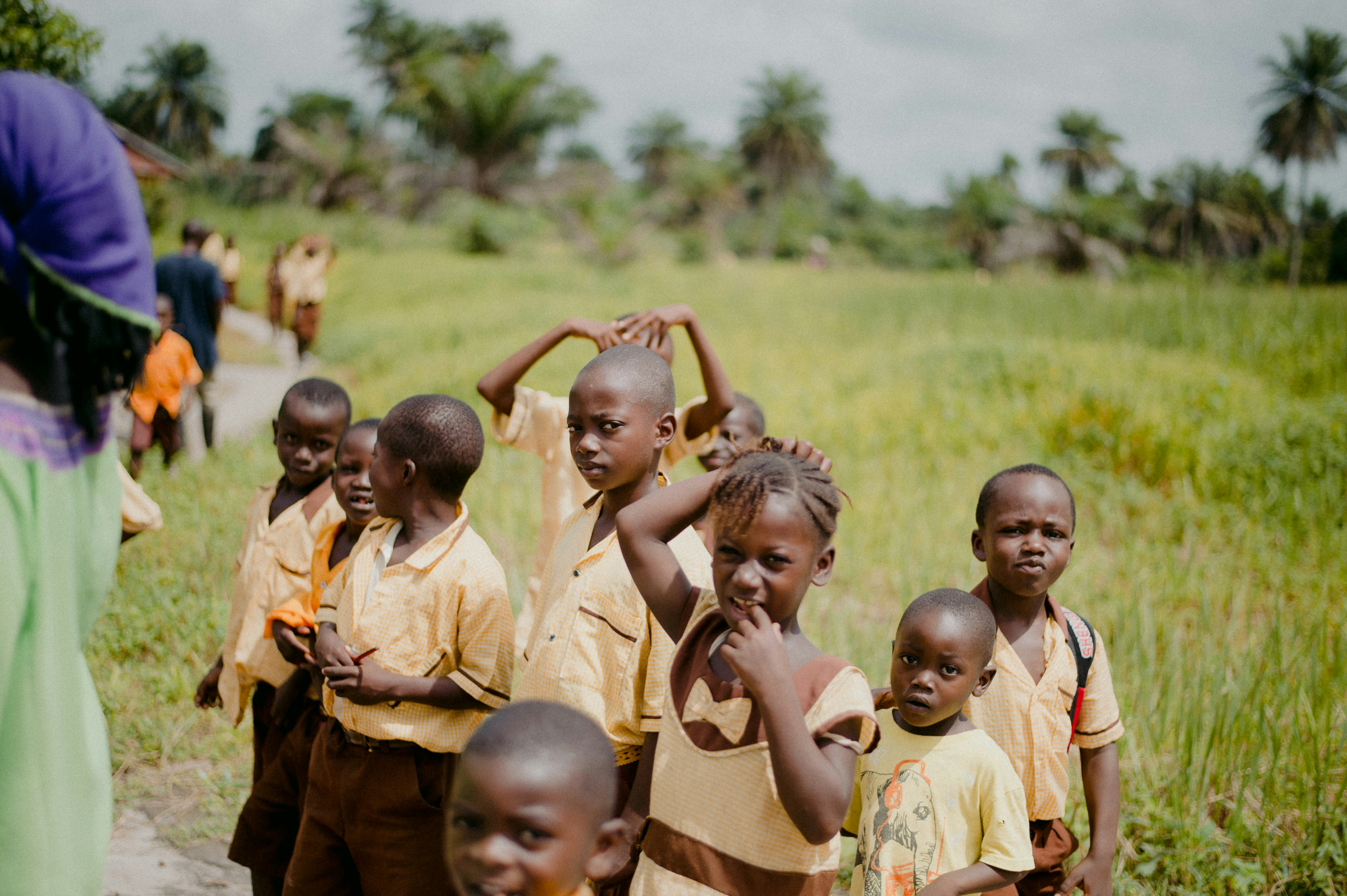 children in yellow shirt standing on green grass field during daytime